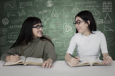 Kara tahta üzerinde karalamalar ile iki öğrenci