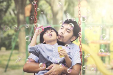 Sabun köpüğü üfleyen çocuk ile Asya adam