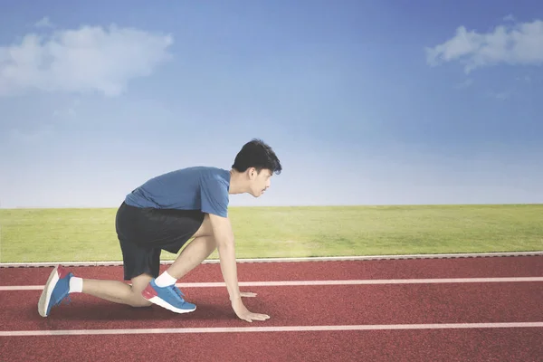 Young man in start position to run — Stock Photo, Image