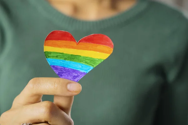 Mujer desconocida sosteniendo un corazón con colores de arco iris — Foto de Stock