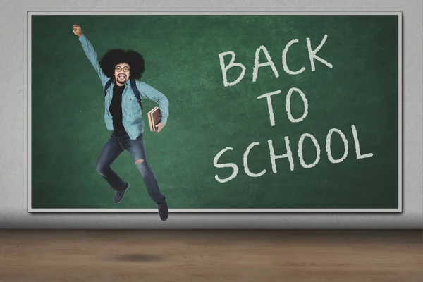 Student jumping with back to school text — Stock Photo, Image