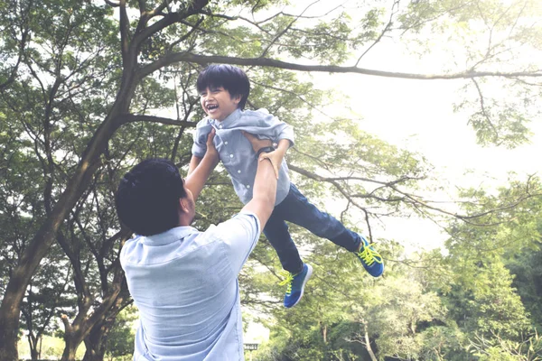 公園で一緒に時間を過ごしながら彼の父によって持ち上げられている男の子の画像 — ストック写真