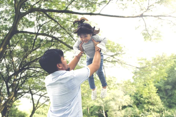 公園で一緒に時間を過ごしながら娘を持ち上げる男性の画像 — ストック写真
