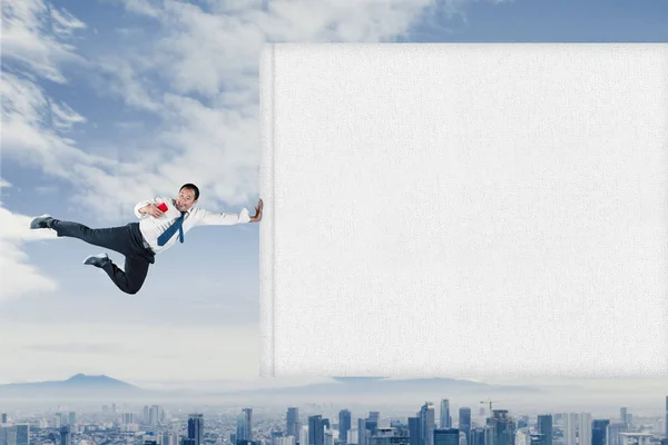 Asian businessman flying with empty banner — Stock Photo, Image