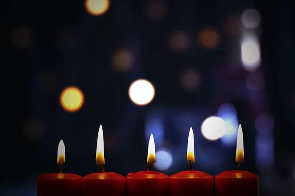 Bougies rouges brûlantes avec lumière de Noël floue — Photo