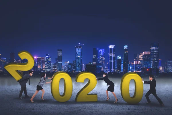 Business people struggling to arranges numbers 2020 — Stock Photo, Image