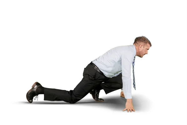 Caucasian businessman kneeling in the studio — Stock Photo, Image