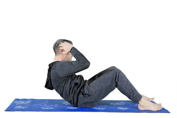 Homem caucasiano fazendo crunches exercício no estúdio — Fotografia de Stock