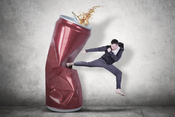 Caucasian man kicking a can of soda drink — Stock Photo, Image