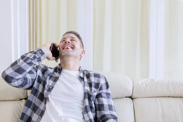 Homem caucasiano rindo enquanto falava em um telefone — Fotografia de Stock