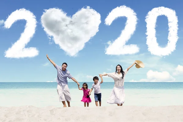 Família alegre com número 2020 na praia — Fotografia de Stock