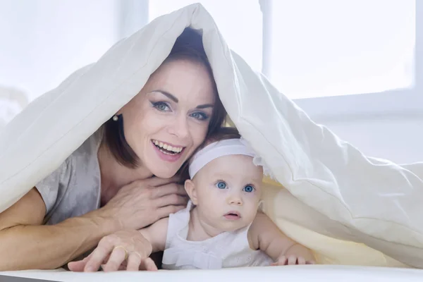 Veselý matka hraje se svým dítětem pod dekou — Stock fotografie