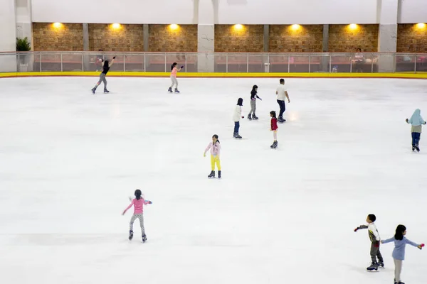 Crowded little children playing ice skating