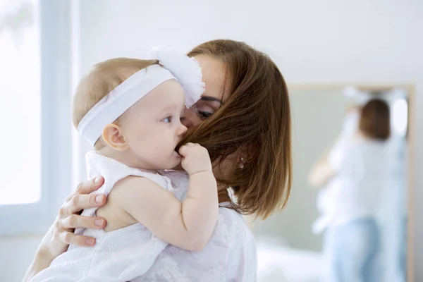 可爱的女婴咬着妈妈的头发 — 图库照片