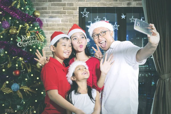 Aile, Noel ağacının yanında selfie çeker. — Stok fotoğraf