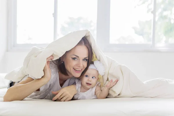 Mãe e seu bebê deitado sob um cobertor — Fotografia de Stock