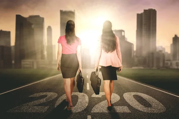 Twee zakenvrouwen lopen boven nummers 2020 — Stockfoto