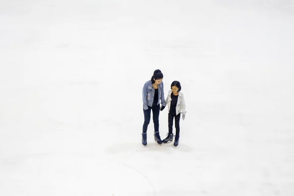 Γυναίκα και παιδί παίζουν πατινάζ στον πάγο — Φωτογραφία Αρχείου