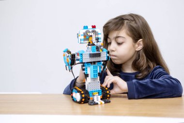 Beyaz kız Lego robotu yapıyor.
