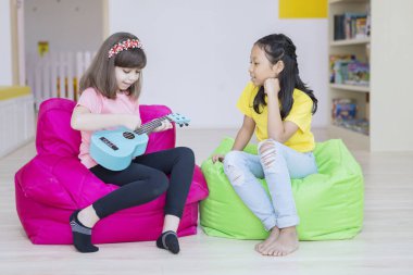 Beyaz kız arkadaşına gitar çalmayı öğretiyor.