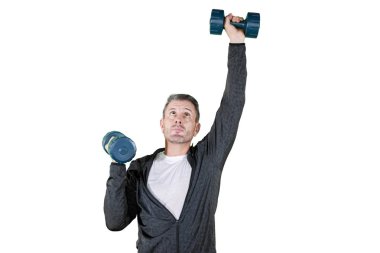 Beyaz adam stüdyoda dambıllarla egzersiz yapıyor.