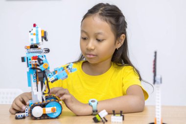 Sınıfta Lego robotu yapan sevimli küçük bir kız.
