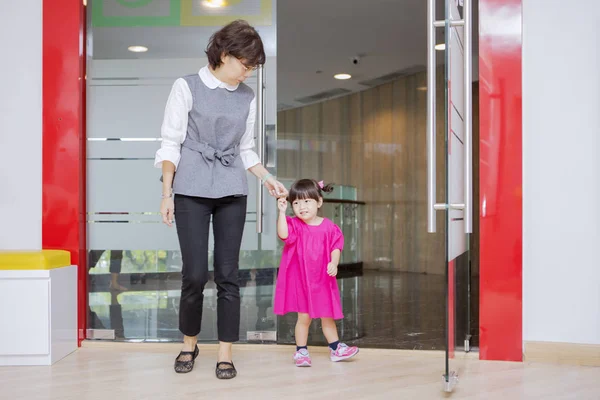 Asiatische Mutter nimmt Ihre Tochter aus einem Kindergarten — Stockfoto