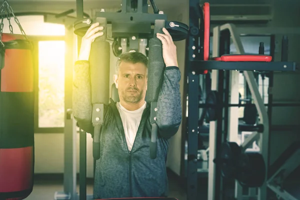 Caucásico hombre haciendo ejercicio con una máquina de fitness —  Fotos de Stock