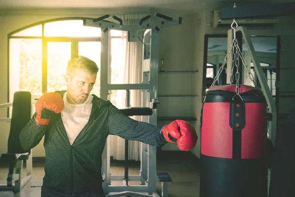 Kaukaski mężczyzna jest ćwiczenia bokserskie w siłowni centrum — Zdjęcie stockowe