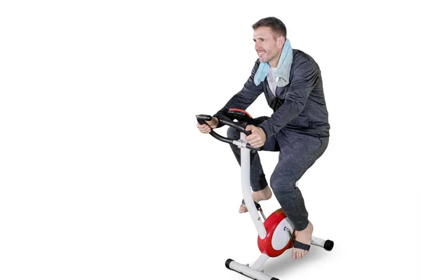 Caucásico hombre entrenamiento con un spin bike en estudio — Foto de Stock