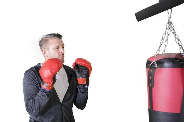 Caucasian man wearing boxing gloves on studio — Stockfoto