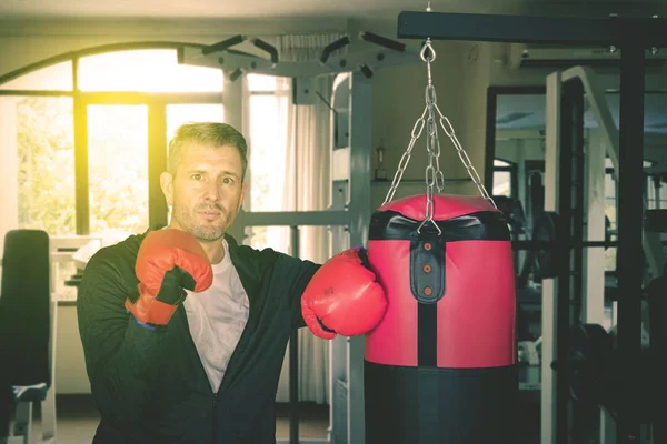 Белый мужчина с боксерской сумкой в спортзале — стоковое фото