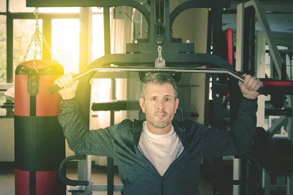 Hombre caucásico con máquina de fitness en el gimnasio —  Fotos de Stock