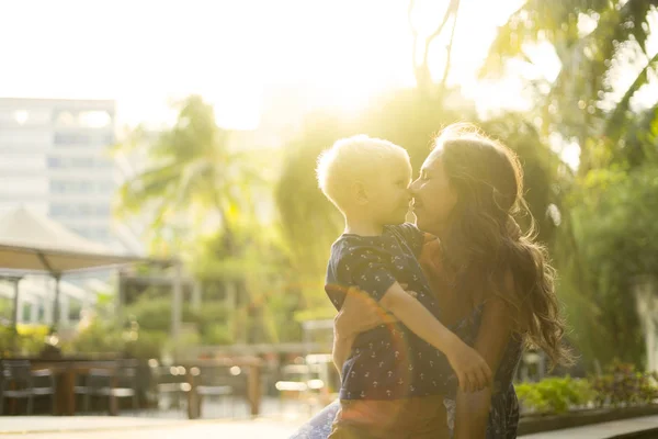 Vit mamma kysser sin son i parken — Stockfoto