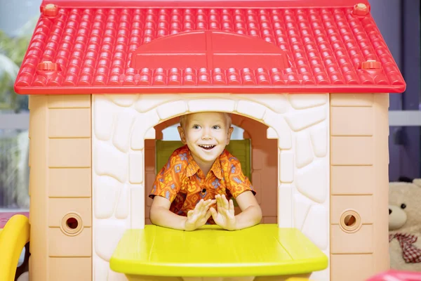 Fröhlicher kleiner Junge spielt im Spielhaus — Stockfoto