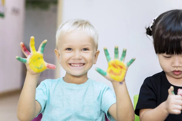 Carino bambino mostrando le mani dipinte con il suo amico — Foto Stock