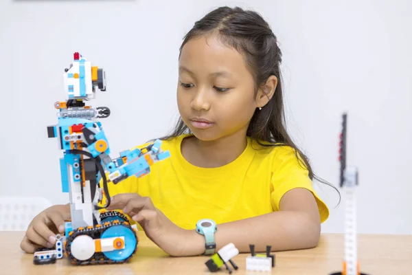 Söt liten flicka bygga en Lego robot i klassen — Stockfoto