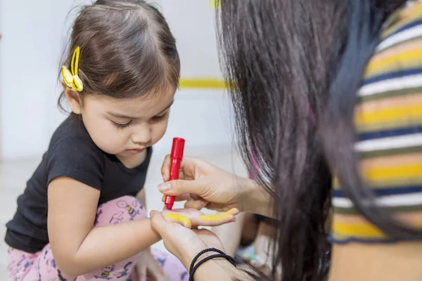 Schattig klein meisje handen gekleurd door haar leraar — Stockfoto