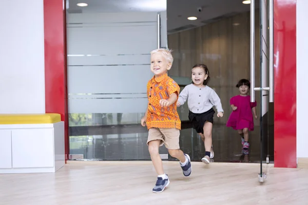 Cute schoolchildren running outside after studying — Stock Photo, Image