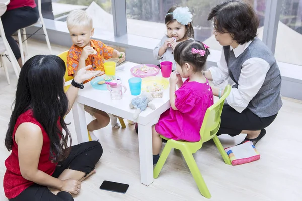 Diversidad niños desayunando con profesores —  Fotos de Stock