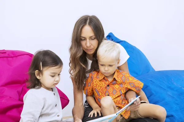 Vrouwelijke leraar leest een boek voor kinderen in de kleuterschool — Stockfoto