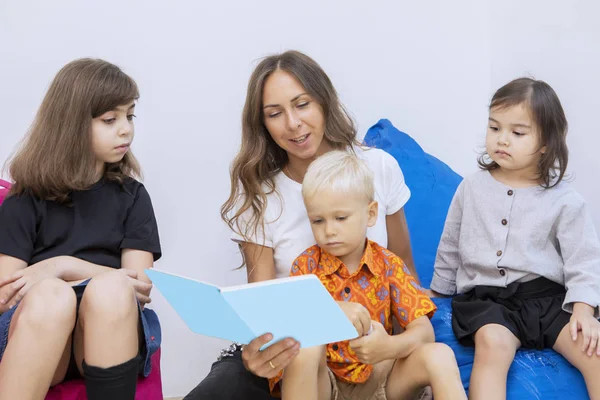 Η δασκάλα διαβάζει ένα παραμύθι σε μια ομάδα παιδιών. — Φωτογραφία Αρχείου