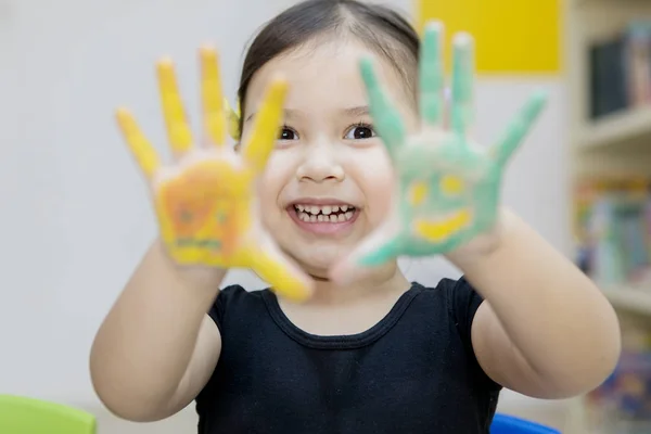 Niña feliz mostrando las manos pintadas — Foto de Stock