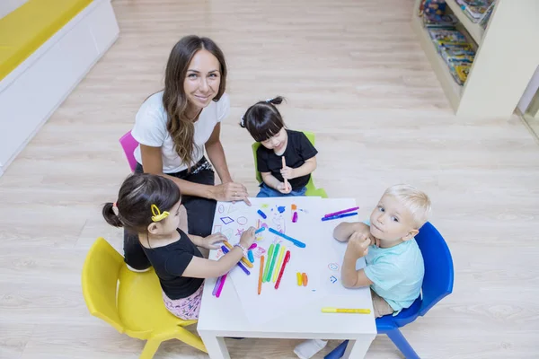 Profesor feliz y estudiantes dibujando con lápices de colores — Foto de Stock
