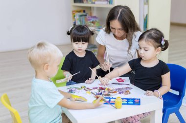 Kreş çocukları öğretmenleriyle resim yapmayı öğreniyorlar.