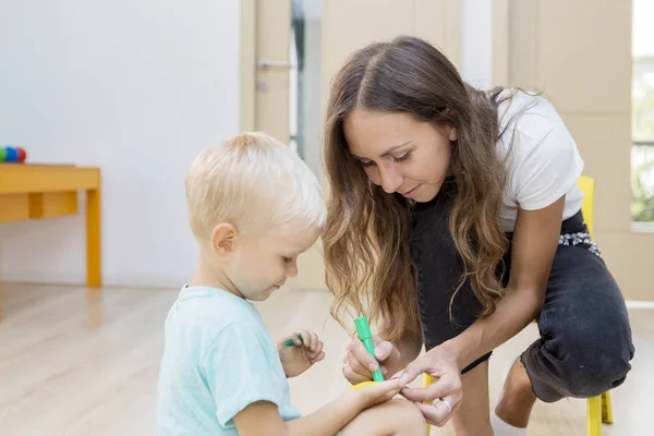 Kleine jongen handen gekleurd door haar leraar — Stockfoto