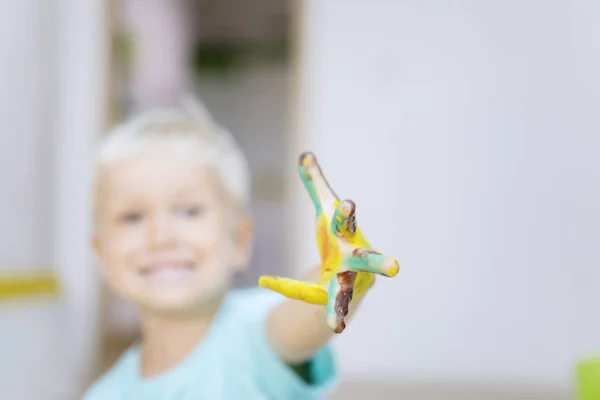 Pequeño niño mostrando una mano sucia con pintura — Foto de Stock