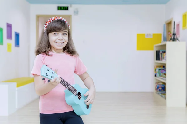 Niña tocando una guitarra en el jardín de infantes — Foto de Stock