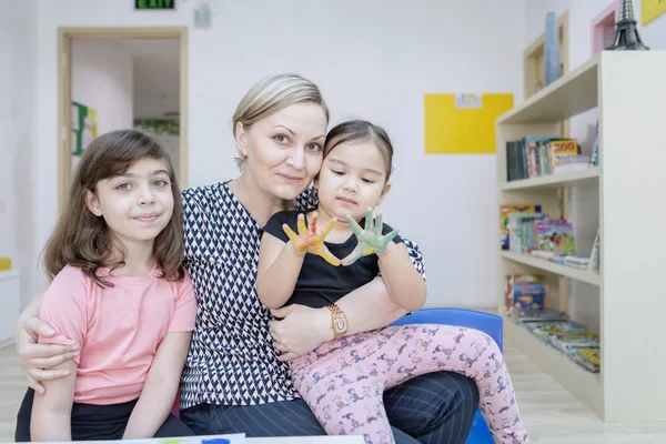 Anaokulunda annesi ve kız kardeşiyle küçük bir kız. — Stok fotoğraf