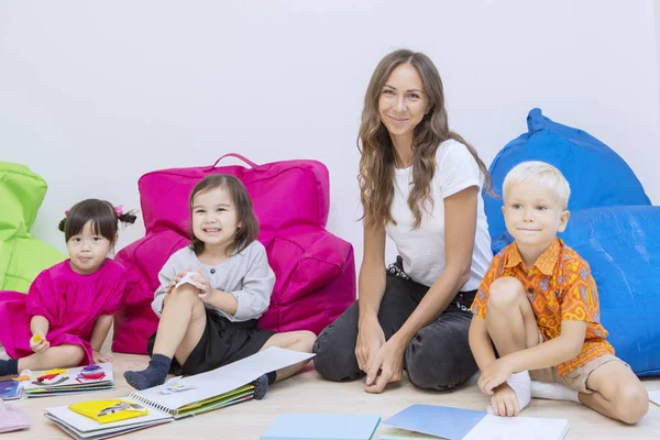 Uśmiechnięta nauczycielka z uczniami w klasie — Zdjęcie stockowe